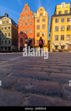 3 Fußgänger Touristen zu Fuß auf den gepflasterten Platz Stortorget, Stockholm, Schweden Stockfoto