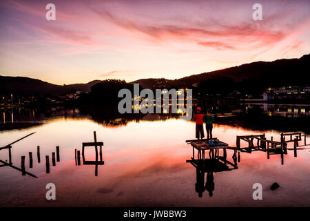 Paar auf einem Deck Conceicao Lagune bei Sonnenuntergang. Florianopolis, Santa Catarina, Brasilien. Stockfoto