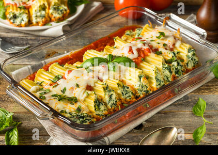 Hausgemachte gefüllt mit Ricotta und Spinat Manicotti mit Basilikum Stockfoto