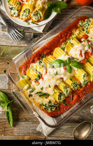 Hausgemachte gefüllt mit Ricotta und Spinat Manicotti mit Basilikum Stockfoto