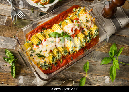 Hausgemachte gefüllt mit Ricotta und Spinat Manicotti mit Basilikum Stockfoto