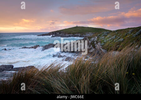 Wellen bei einem Sonnenuntergang in der Nähe von Fistral Beach in Newquay, Cornwall, Großbritannien Stockfoto