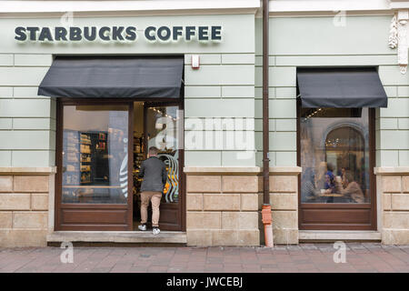 Krakau, Polen - Januar 14, 2017: die Menschen besuchen Starbucks coffeehouse in der Altstadt. Starbucks Corporation ist ein US-amerikanischer berühmten Coffee Company und coff Stockfoto