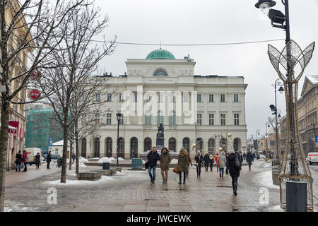 Warschau, Polen - 16 Januar, 2017: unbekannte Menschen zu Fuß entlang winter Staszic Palace und Denkmal der Astronom Nikolaus Kopernikus. Warschau ist die Stockfoto