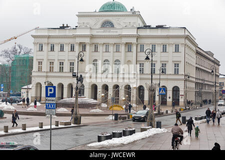 Warschau, Polen - 16 Januar, 2017: unbekannte Menschen zu Fuß entlang winter Staszic Palace und Denkmal der Astronom Nikolaus Kopernikus. Warschau ist die Stockfoto