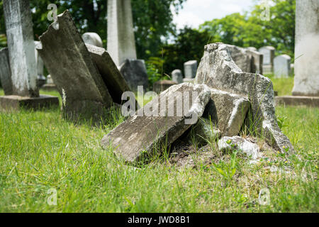 Gebrochen und verlassenen Grabsteine in Rochester, New York. Hebräische Schrift auf dem Stein Stockfoto