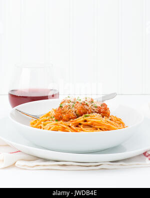 Teller Spaghetti mit Fleischbällchen garniert mit frischen Kräutern und Parmesan. Stockfoto