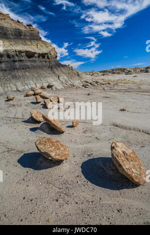 Härter Felsen erodiert aus den weichen ashy Ton mit einer geschichteten Hügel hinter, in der Bisti De-Na-Zin Wilderness / in der Nähe von Farmington, New Mexico, USA Stockfoto