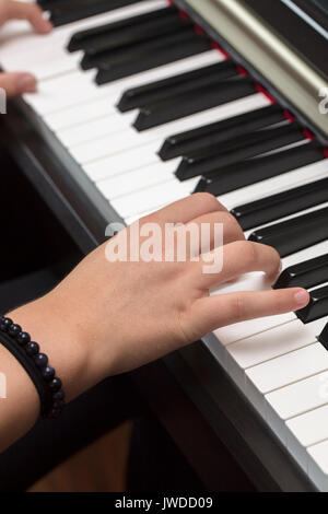 Junge person spielen und üben das Klavier auf den weißen und schwarzen Tasten Stockfoto