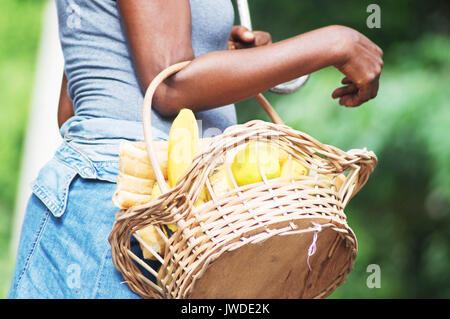 Junge Frau mit einem Korb voller Bestimmungen. Stockfoto