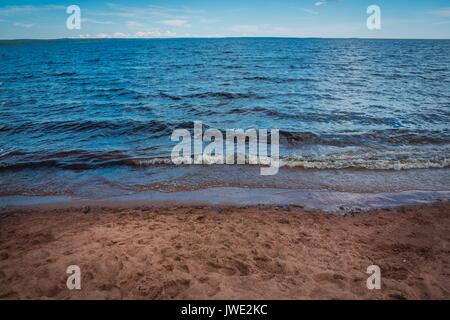 Blick auf den See, Himmel und Wolken von der sandigen Ufer. Stockfoto