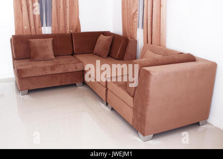L-förmigen Sofa Möbel luxuriös mit Kissen, die weiße Wand Farbe Hintergrund. Stockfoto