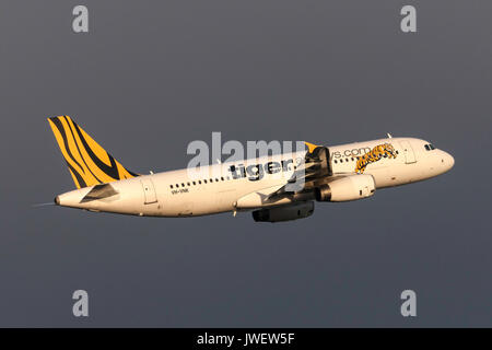 Low Cost Airline Tiger Airways Airbus A320-232 VH-vnk Abfahrt Melbourne International Airport mit dunklen Gewitterwolken hinter sich. Stockfoto