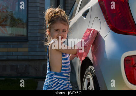 Portrait kleine süße Mädchen wäscht Auto in sonnigen Tag Stockfoto