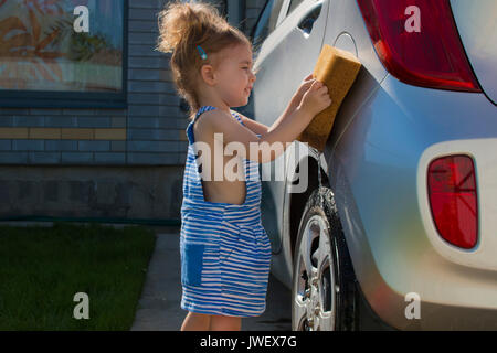 Kleine süße Mädchen wäscht Auto in sonnigen Tag Stockfoto