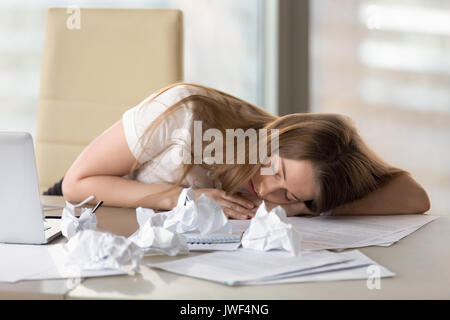 Erschöpft, müde Frau schlafen am Schreibtisch nach Überarbeitung im Büro Stockfoto