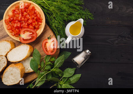 Vorbereitung köstliche italienische Tomaten Bruschetta mit gehacktem Gemüse, Kräutern und Öl Stockfoto