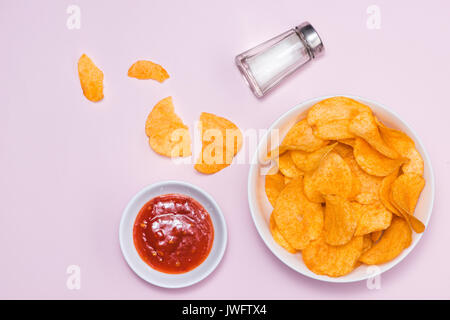 Konzept für ungesunde Lebensmittel. Kartoffel-Chips in eine Schüssel geben und ketchup Stockfoto