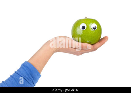 Weibliche Hand green apple mit kulleraugen auf weißem Hintergrund mit Kopie Raum isoliert. Gesundes Essen und Lifestyle Konzept Stockfoto