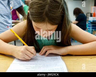 Zurück zu Schule. Die vierte Klasse Mädchen, im Alter von zehn, in der Schule im Unterricht arbeiten, mit Bleistift und Arbeitsblatt. North Florida, USA Stockfoto