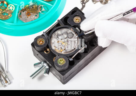 Uhrmacher Werkstatt - Reparatur alte mechanische Uhr ganz nah am weißen Tisch Stockfoto
