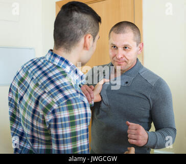Zwei wütende junge Männer kämpften an der Tür Stockfoto