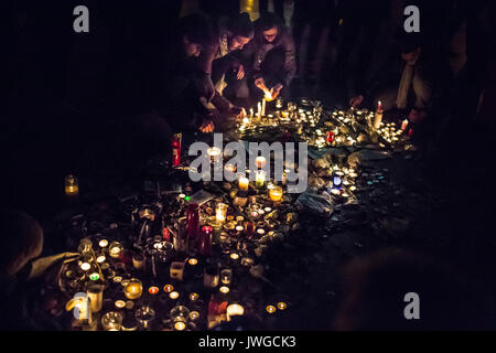 Teppich von Kerzen mit einem woamn eine Kerze anzünden. Hommage an die Opfer von Charlie Hebdo Tötung in Paris der 7. Januar 2015. Stockfoto