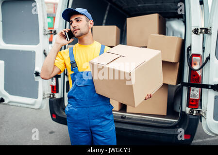 Cargo Lieferservice, männlichen Kurier in Uniform mit Box und Handy in den Händen. Leerer Behälter Stockfoto