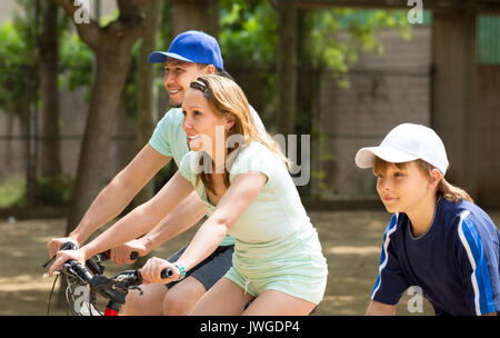 Mann mit Ehefrau und Sohn Fahrrad im Park im Urlaub Stockfoto