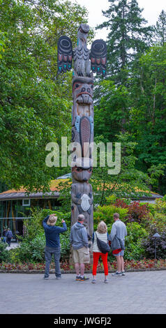 Besucher bewundern einen Totempfahl liegt in den Butchart Gardens Victoria Vancouver Island British Columbia Kanada Stockfoto