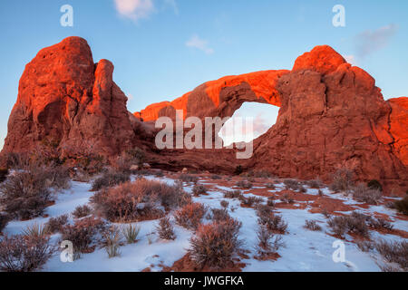 Abendsonne spiegelt sich auf dem Fenster Arch im Arches National Park, Moab, Utah, im Winter. Stockfoto