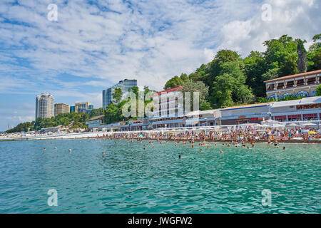 Sochi, Russland - 06. Juli 2017. die Leute Schwimmen und Sonnenbaden am Strand der Stadt Sotschi. Strand mit Touristen, Sonnenliegen und Sonnenschirmen Stockfoto