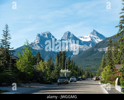 Eine breite Wohnstraße in Canmore mit Pinienwald und den Rocky Mountains im Banff National Park, Alberta, Kanada Stockfoto