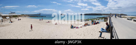 Menschen am Playa Chica, Strand am Ende der Hafen von Tarifa mit Blick auf die Straße von Gibraltar und Marokko, mit der Statue Sagrado Corazon de Jesus Stockfoto