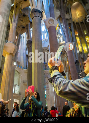 Touristen sind die Bilder mit ihren Smartphones innerhalb von Barcelona Sagrada Familia Kathedrale, mit Besuchern aus aller Welt überfüllt ist Stockfoto