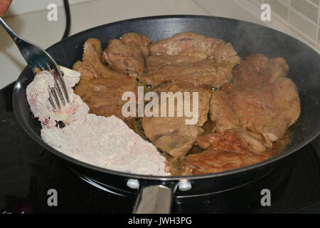 Kochen Fleisch in einem Topf auf einer induktionsplatte Stockfoto