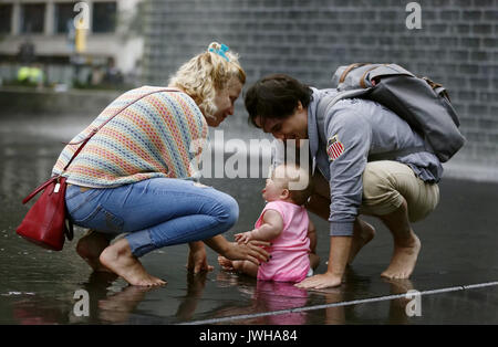 Chicago, USA. 11 Aug, 2017. Menschen spielen bei der Crown Fountain in Millennium Park in der Innenstadt von Chicago, USA, am 12.08.11, 2017. Crown Fountain ist ein interaktiver Arbeit der öffentlichen Kunst und video Skulptur in Chicago, Millennium Park vorhanden. Der Brunnen besteht aus schwarzem Granit einen reflektierenden Pool zwischen ein paar Glasbaustein Türme mit LED-Display digitale Videos auf Ihr inneres Gesicht zu zeigen. Credit: Wang Ping/Xinhua/Alamy leben Nachrichten Stockfoto