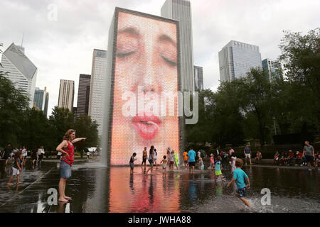 Chicago, USA. 11 Aug, 2017. Menschen spielen bei der Crown Fountain in Millennium Park in der Innenstadt von Chicago, USA, am 12.08.11, 2017. Crown Fountain ist ein interaktiver Arbeit der öffentlichen Kunst und video Skulptur in Chicago, Millennium Park vorhanden. Der Brunnen besteht aus schwarzem Granit einen reflektierenden Pool zwischen ein paar Glasbaustein Türme mit LED-Display digitale Videos auf Ihr inneres Gesicht zu zeigen. Credit: Wang Ping/Xinhua/Alamy leben Nachrichten Stockfoto