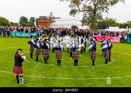 Glasgow, UK. 12 Aug, 2017. Es wurde geschätzt, dass mehr als 10.000 Zuschauer stellte sich dann heraus, dass der letzte Tag der "Rohrleitungen Live' und dem World Pipe Band Championships, eine international bekannte Wettbewerb zu beobachten, in Glasgow Green, da das Finale eine Woche der Unterhaltung und kostenlose Konzerte, die um das Stadtzentrum von Glasgow genommen haben. Trotz der gelegentlichen heftiger Regenschauer, Spielen fortgesetzt und Geister waren nicht gedämpft. Credit: Findlay/Alamy leben Nachrichten Stockfoto