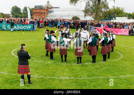 Glasgow, UK. 12 Aug, 2017. Es wurde geschätzt, dass mehr als 10.000 Zuschauer stellte sich dann heraus, dass der letzte Tag der "Rohrleitungen Live' und dem World Pipe Band Championships, eine international bekannte Wettbewerb zu beobachten, in Glasgow Green, da das Finale eine Woche der Unterhaltung und kostenlose Konzerte, die um das Stadtzentrum von Glasgow genommen haben. Trotz der gelegentlichen heftiger Regenschauer, Spielen fortgesetzt und Geister waren nicht gedämpft. Credit: Findlay/Alamy leben Nachrichten Stockfoto