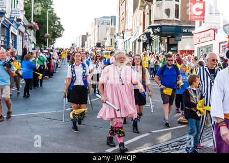 Broadstairs Folk Woche Festival Parade in der High Street. Royal Freiheit gemischte Morris Seite marschieren entlang der Straße führen durch ihre Narr, Maurice, älterer bärtiger Mann, in seiner traditionellen rosa Kleid. Stockfoto