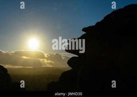 Haytor, Dartmoor, Devon, Großbritannien. 12. August 2017. UK Wetter. Die sonne Silhouetten der Felsen an Haytor im darmoor Nationalpark, Devon, an einem warmen, sonnigen Abend. Photo Credit: Graham Jagd-/Alamy leben Nachrichten Stockfoto