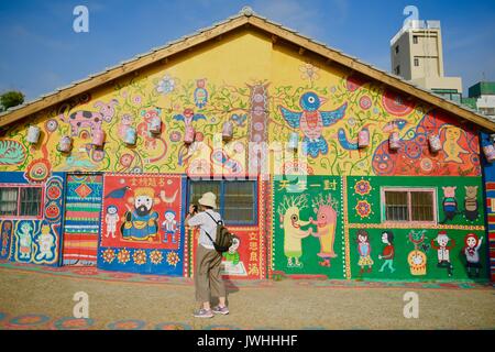 Taichung, Taiwan in China. 12 Aug, 2017. Touristen besuchen einer Wohnanlage "Rainbow Village" in der Nantun District von Taichung City, Südosten Chinas Taiwan, 12.08.2017. Huang Yong-fu, ein 95-jähriger Veteran, lackiert bunten Tiere und Figuren an den Wänden und die Anlage des Dorfes vor ein paar Jahren. Seine Gemälde zog viele Touristen und auch gespeichert, die Sterbenden Dorf entfernt werden. Er erhält noch bis um 3 Uhr morgens jeden Tag die Gemälde seines Dorfes zu reparieren. Credit: Zhou Mi/Xinhua/Alamy leben Nachrichten Stockfoto