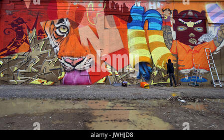 Würzburg, Deutschland. 12 Aug, 2017. Ein Graffiti-künstler sprühen Farben der Wand eines alten Supermarkt in der ehemaligen US-Kaserne in Würzburg, Deutschland, 12. August 2017. Street Artists aus der ganzen Welt sind die Einberufung in der bayerischen Stadt für die Streetmeet Festival, eine Woche lang Graffiti Festival. Foto: Karl-Josef Hildenbrand/dpa/Alamy leben Nachrichten Stockfoto