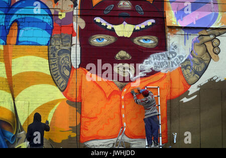 Würzburg, Deutschland. 12 Aug, 2017. Ein Graffiti-künstler sprühen Farben der Wand eines alten Supermarkt in der ehemaligen US-Kaserne in Würzburg, Deutschland, 12. August 2017. Street Artists aus der ganzen Welt sind die Einberufung in der bayerischen Stadt für die Streetmeet Festival, eine Woche lang Graffiti Festival. Foto: Karl-Josef Hildenbrand/dpa/Alamy leben Nachrichten Stockfoto