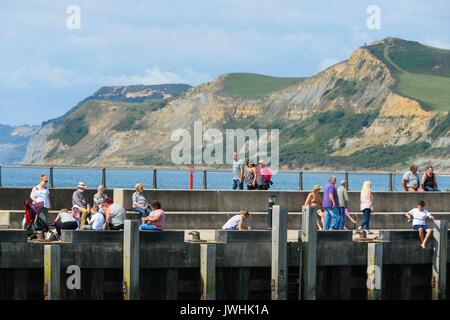 West Bay, Dorset, Großbritannien. Am 13. August 2017. UK Wetter. Urlauber genießen eine entlang der Jurassic Pier die warme Sonne am Strand von West Bay in Dorset schlendern. Photo Credit: Graham Jagd-/Alamy leben Nachrichten Stockfoto