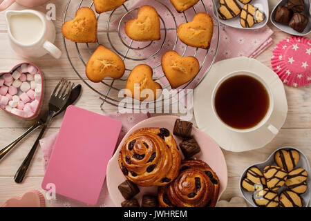 Flach Kuchen und Kekse, Muffins und Brötchen, Gebäck und Süßigkeiten, Tee und Kaffee mit Marshmallow. Ansicht von oben. Stockfoto