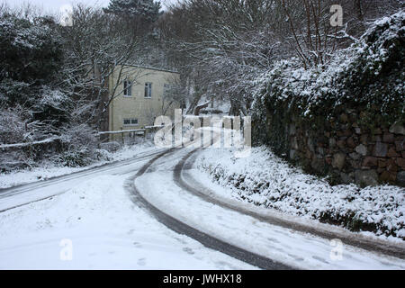 Britische Kanalinseln. Alderney. Winter Szene von Cottage und verschneiten Feldweg. Stockfoto