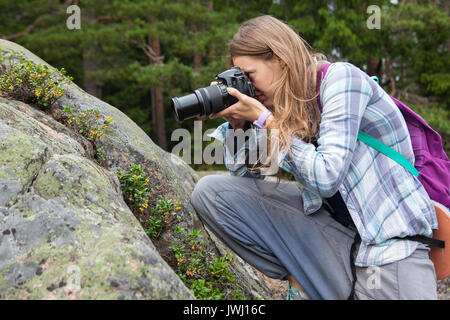 Junge Frau Fotos im Herbst Wald mit Kamera Stockfoto