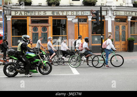 Radfahrer Pendler Pendler auf dem Fahrrad ausserhalb der Hut & Federn Pub an der Ecke von Clerkenwell Rd & Goswell Straßen in London UK KATHY DEWITT gestoppt Stockfoto